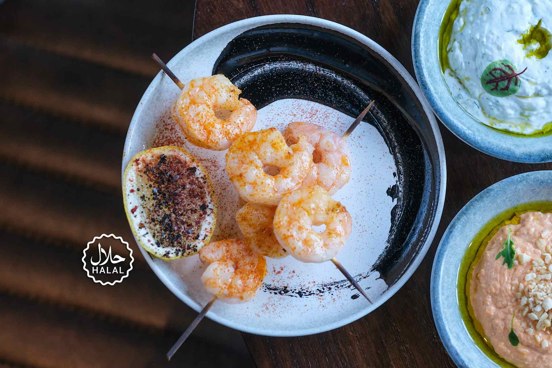 Hackney-style halal grilled shrimp skewers with zesty lemon and fresh Mediterranean dips.