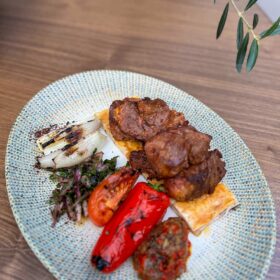 Juicy lamb kebab with fire-roasted peppers and grilled onions at Zula Grill, the best grill restaurant in Hackney.